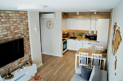 a kitchen and living room with a brick wall at Apartament Bulwary 3 in Oświęcim