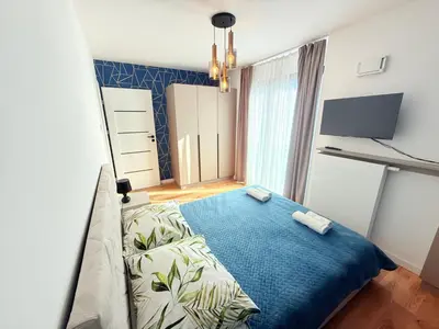 a bedroom with a bed and a blue blanket at Vistula Avenue Apartment free Parking in Kraków