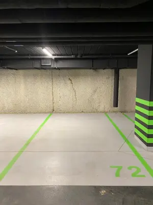 an empty parking garage with green lines on the floor at Vistula Avenue Apartment free Parking in Kraków