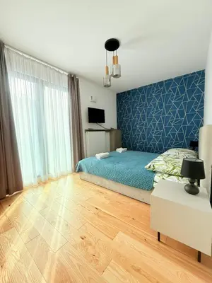 a bedroom with a bed and a blue wall at Vistula Avenue Apartment free Parking in Kraków