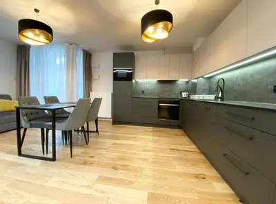 a kitchen with a table and chairs in a room at Vistula Avenue Apartment free Parking in Kraków