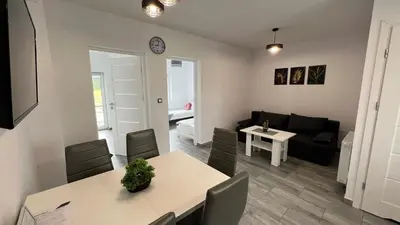 a living room with a table and a couch at Apartamenty Izabell by Housine in Zator