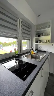 a kitchen with a sink and a counter top at Apartamenty Izabell by Housine in Zator