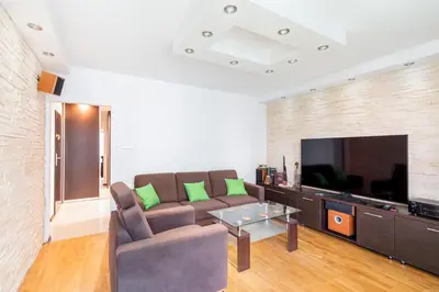 a living room with a couch and a flat screen tv at Prokocim Podłęska Studio by BookingHost in Kraków