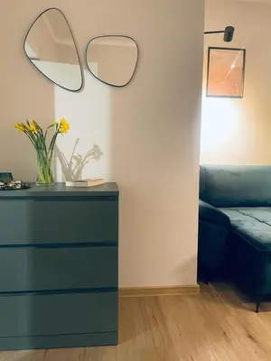 a living room with a blue dresser and a mirror at MR HOME APARTMENTS - Mogilska in Kraków