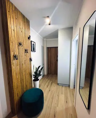 a living room with a green ottoman in front of a door at MR HOME APARTMENTS - Mogilska in Kraków