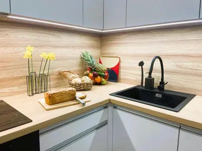 a kitchen with a sink and a cutting board with fruit at MR HOME APARTMENTS - Mogilska in Kraków