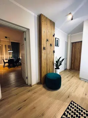 a living room with a green ottoman in front of a door at MR HOME APARTMENTS - Mogilska in Kraków