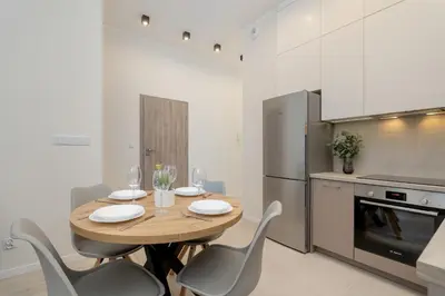 a kitchen with a table and chairs and a refrigerator at Luxury Apartment near the City Center of Cracow by Renters Prestige in Kraków