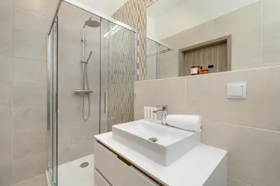 a bathroom with a white sink and a shower at Luxury Apartment near the City Center of Cracow by Renters Prestige in Kraków