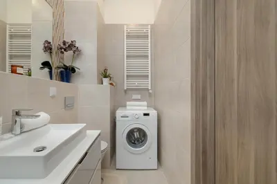 a bathroom with a washing machine and a sink at Luxury Apartment near the City Center of Cracow by Renters Prestige in Kraków