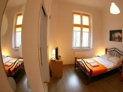 two beds in a room with two windows at VisitKrak in Kraków