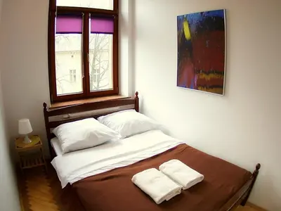 a bedroom with a bed with two towels on it at VisitKrak in Kraków