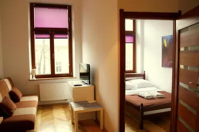a small room with a bed and a television at VisitKrak in Kraków