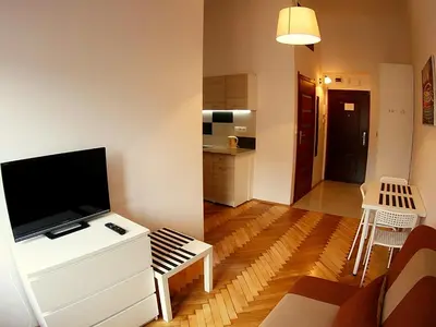 a living room with a television on a white dresser at VisitKrak in Kraków