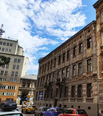 an old building with cars parked in front of it at VisitKrak in Kraków