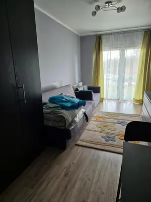 a living room with a bed and a couch at Apartament Bunsha Kraków in Kraków