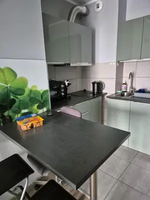 a kitchen with a black table with chairs in it at Apartament Bunsha Kraków in Kraków