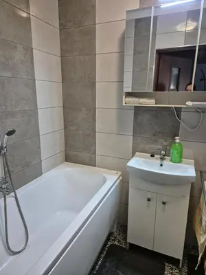 a bathroom with a white tub and a sink at Apartament Bunsha Kraków in Kraków
