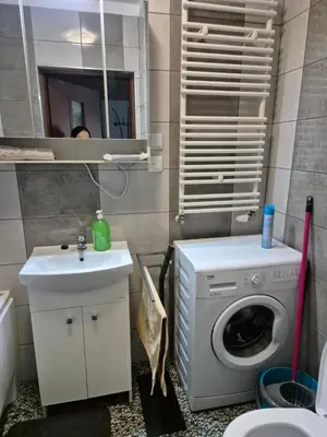 a bathroom with a washing machine and a sink at Apartament Bunsha Kraków in Kraków
