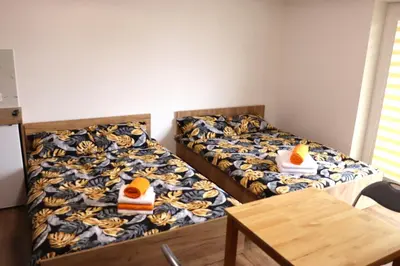 two beds in a room with towels on them at Apartamenty Zator Energy Rest in Zator