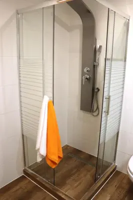 a shower with an orange towel in a bathroom at Apartamenty Zator Energy Rest in Zator