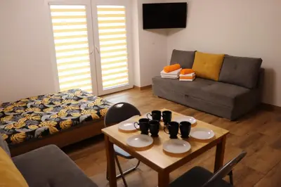 a living room with a couch and a table at Apartamenty Zator Energy Rest in Zator