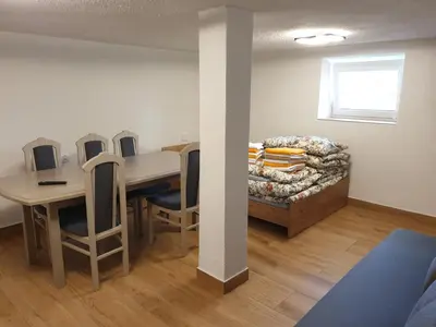 a room with a table and chairs and a couch at Apartamenty Zator Energy Rest in Zator
