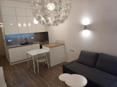 a living room with a couch and a table and a kitchen at Studio Przemyska Cracow's Kazimierz in Kraków