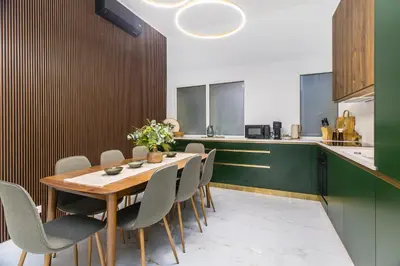 a kitchen and dining room with a wooden table and chairs at BOB Elite Apartments in Kraków