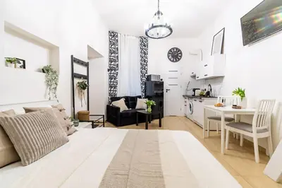 a white living room with a kitchen and a dining room at Old Town Studio Wawel in Kraków