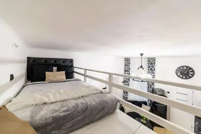 a bedroom with a bed and a clock on the wall at Old Town Studio Wawel in Kraków