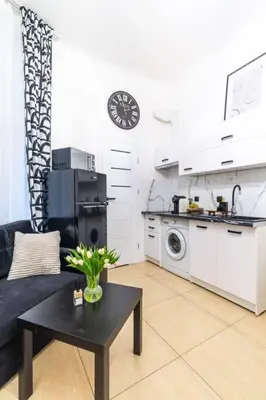 a living room with a black table and a kitchen at Old Town Studio Wawel in Kraków