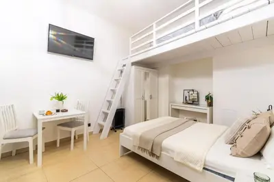 a bedroom with a bed and a loft bed with a desk at Old Town Studio Wawel in Kraków