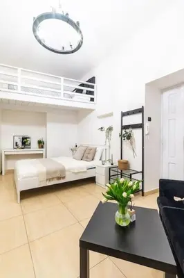 a living room with a loft bed and a table at Old Town Studio Wawel in Kraków