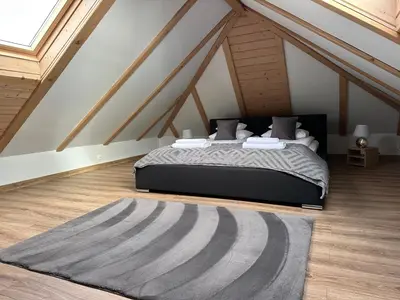 a bedroom with a bed in an attic at Bąbelkowa Chata Beskidy Domek z Balią Jacuzzi in Gilowice