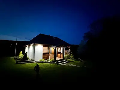 a small house in a yard at night at Bąbelkowa Chata Beskidy Domek z Balią Jacuzzi in Gilowice