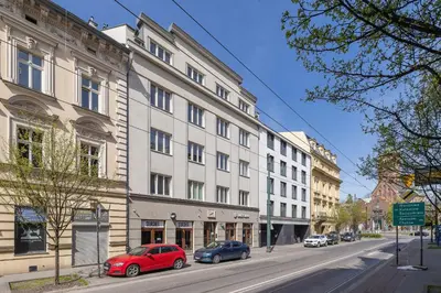 a street with cars parked in front of a building at Rakowicka Modern Studio in Downtown Cracow by Rent like home in Kraków