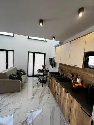 a kitchen and living room with a couch and a table at ZATOR Domki INTERSTYL, Energylandia in Zator