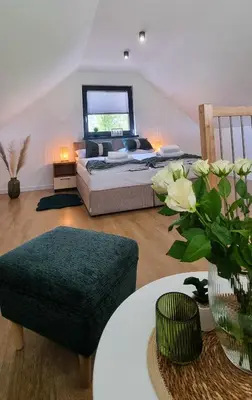 a bedroom with a bed and a table with a couch at ZATOR Domki INTERSTYL, Energylandia in Zator