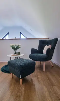 a living room with a chair and a table at ZATOR Domki INTERSTYL, Energylandia in Zator