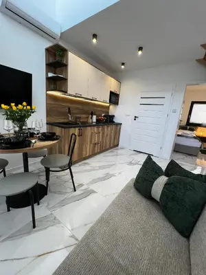 a living room with a couch and a table and a kitchen at ZATOR Domki INTERSTYL, Energylandia in Zator
