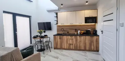 a kitchen with a counter and a table with chairs at ZATOR Domki INTERSTYL, Energylandia in Zator