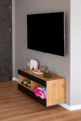 a flat screen tv on a wall with a wooden entertainment center at Willa Olimpia in Podzamcze