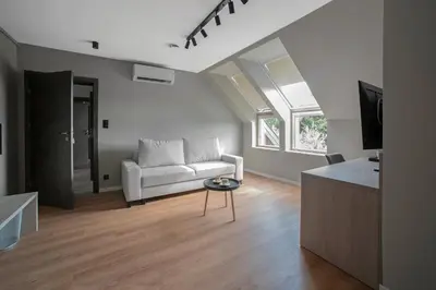 a living room with a white couch and a tv at Willa Olimpia in Podzamcze