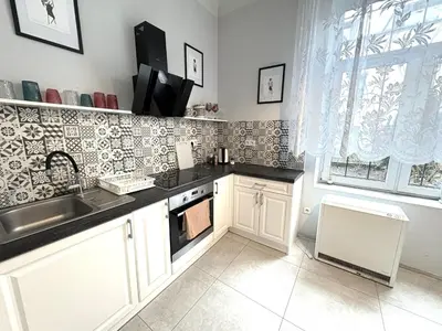 a kitchen and dining room with a table and chairs at YOONIK APARTMENTS in Kraków