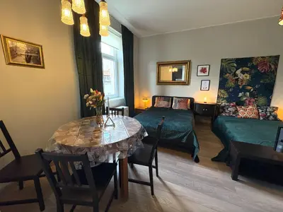 a living room with a table and a bed and a couch at YOONIK APARTMENTS in Kraków