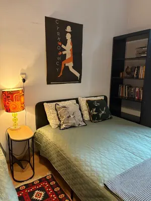 a small room with a bed and a lamp at YOONIK APARTMENTS in Kraków