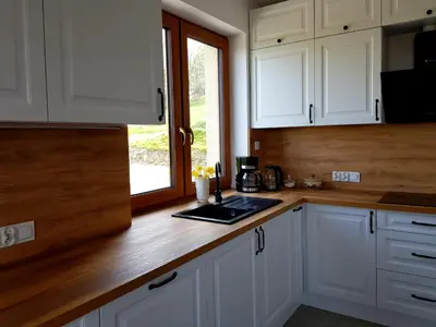a kitchen with white cabinets and a counter top at Surzynówka in Stryszawa