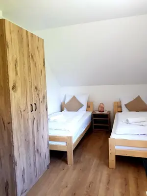 two twin beds in a room with wooden doors at Surzynówka in Stryszawa